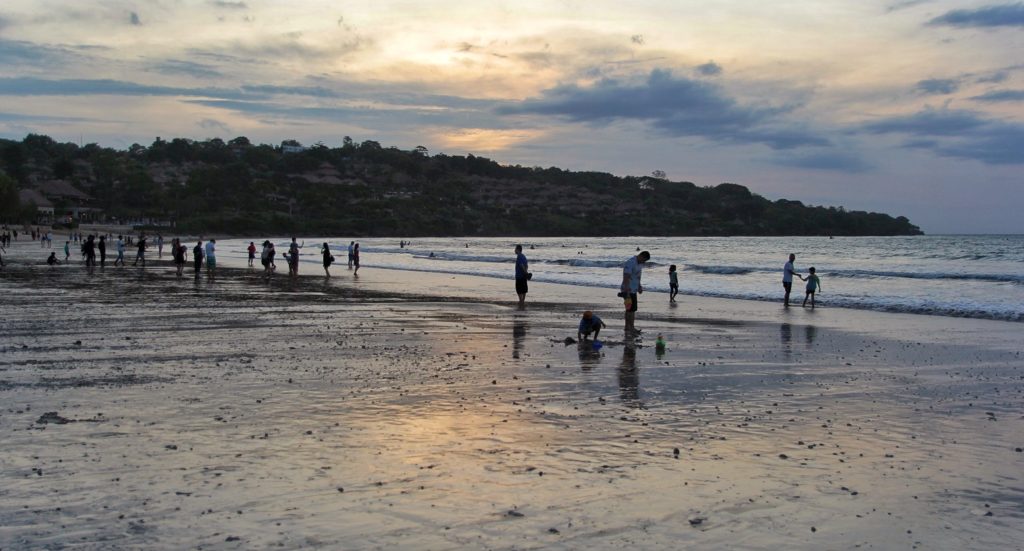 Viele Menschen stehen am Wasser und genießen den Abend.