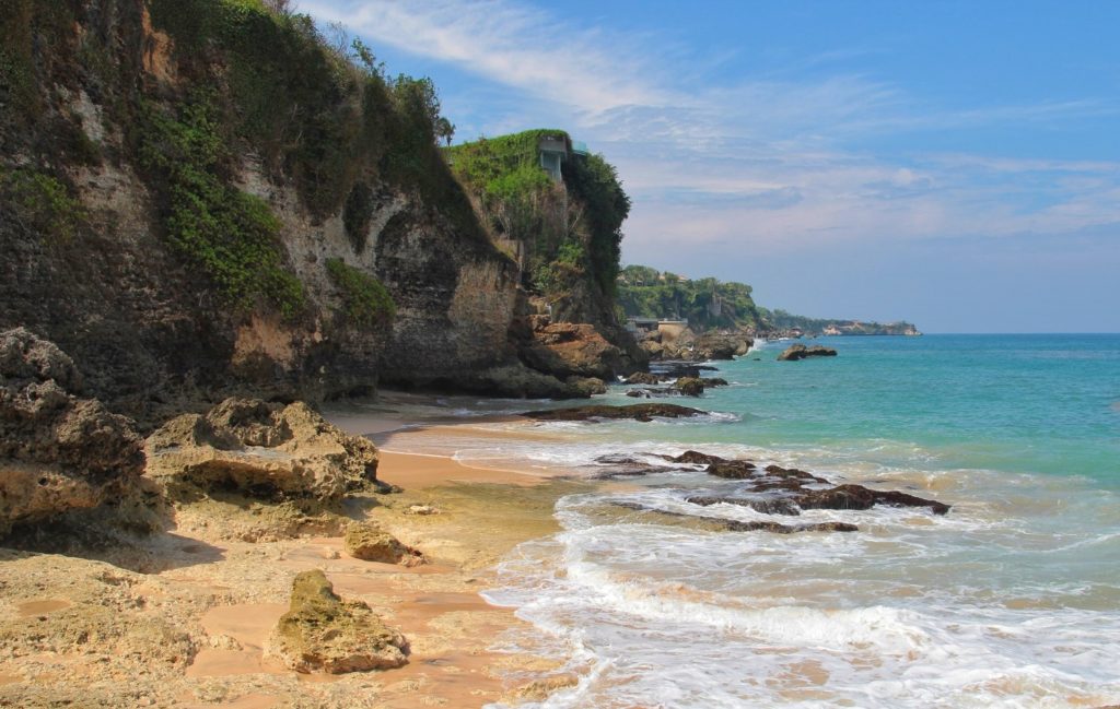 Der Tegal Wangi Beach ist versteckt zwischen zerklüfteten Felsen. Der Ausblick geht entlang der Steilküste, auf der wildes Gestrüpp wächst.